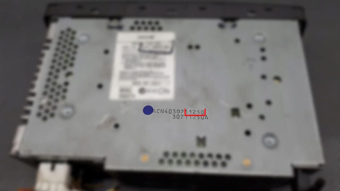 The underside of a Jaguar sat nav head unit, the serial etched into the casing with its last five digits boxed in red