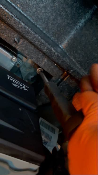 Undoing the bolts that hold the navigation DVD rack in the boot