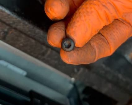 One of the four Torx T25 screws removed